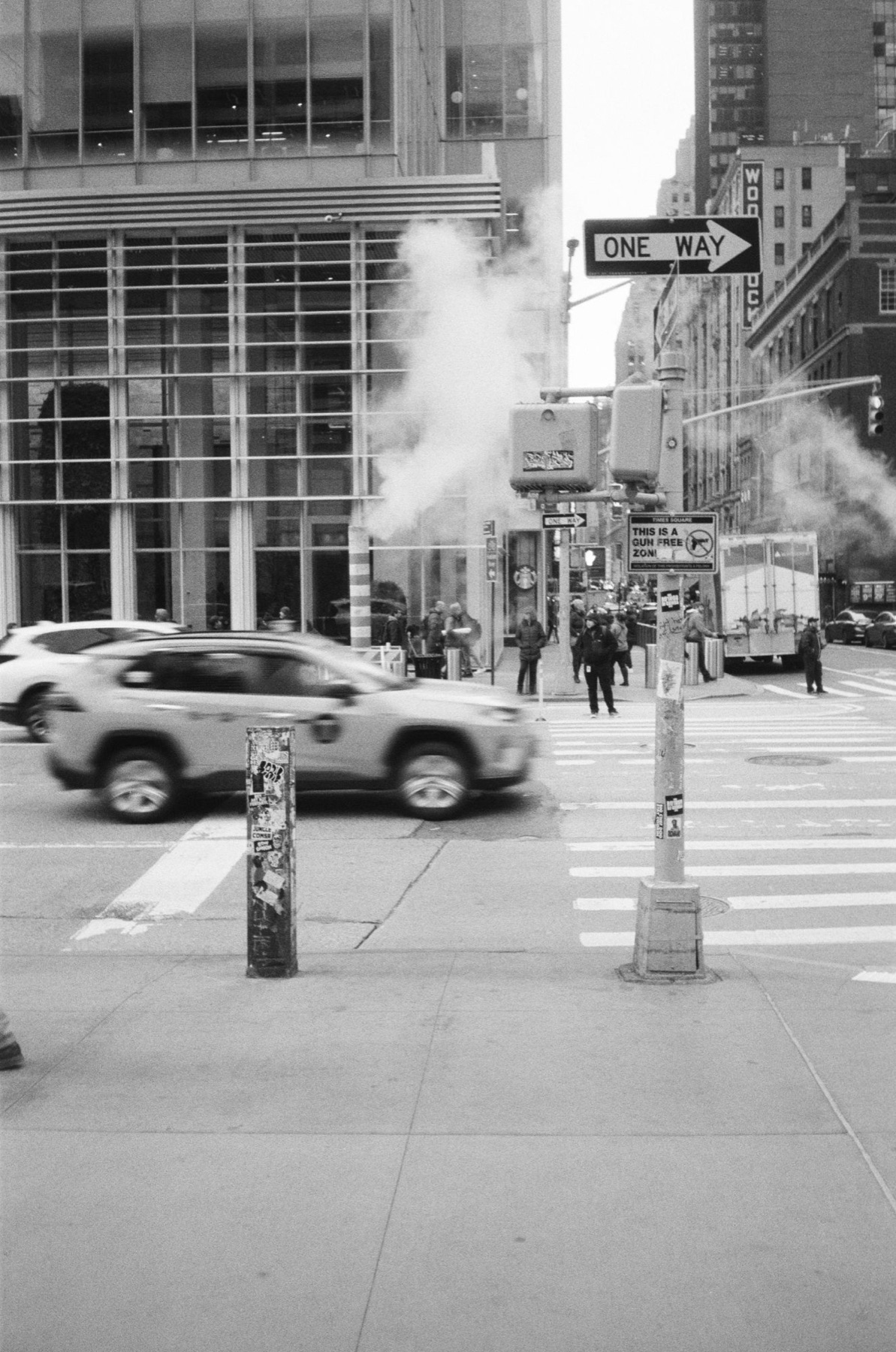 Straßenkreuzung in New York: Taxi in Bewegung, Dampf aus dem Boden und ein One-Way-Schild